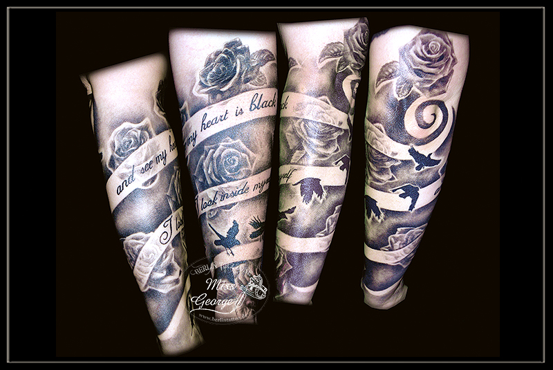 tattoo um arm gehendes band mit schrift und hintergrund mit schwarzen rosen und kraehen von miss george